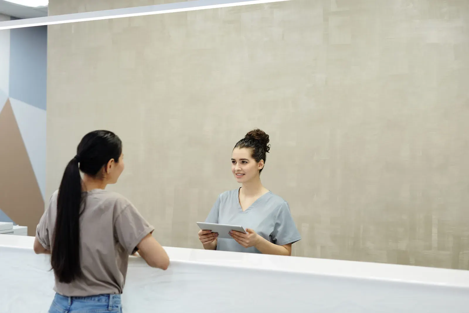 A clinic front desk, where someone is greeted with a tablet.